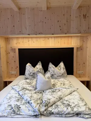 a bed with pillows on it in a room at Mesnerhof my Paradise in Fiè