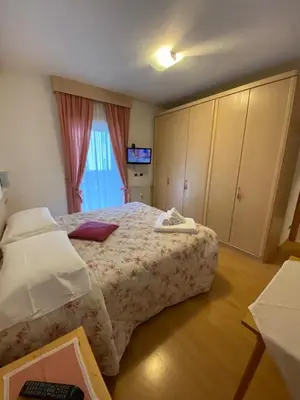 a bedroom with a large bed and a window at Cesa Bernard in Pozza di Fassa