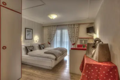 a bedroom with a white bed and a window at Hotel Luianta in Colfosco