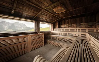 a sauna with benches and a large window at Hotel Goldknopf in Alpe di Siusi