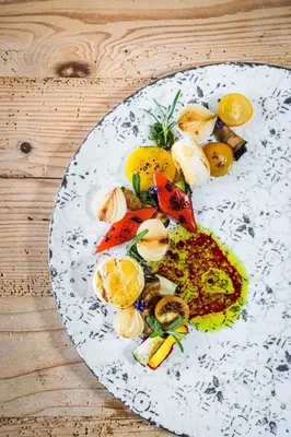 a blue plate of food with pasta and mushrooms at Hotel Goldknopf in Alpe di Siusi