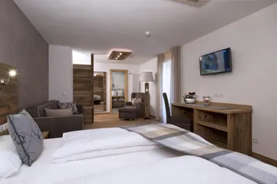a bedroom with a bed and a couch at Hotel Italia in Corvara in Badia