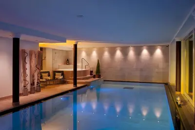 a swimming pool in a house with a bathroom at Hotel Italia in Corvara in Badia
