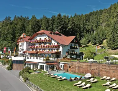 a hotel with a swimming pool and a resort at Granpanorama Wellnesshotel Sambergerhof Superior in Villandro