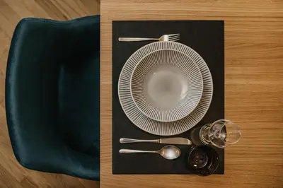 a plate and spoon on a black napkin at Miraval Perathoner Andreas in Ortisei