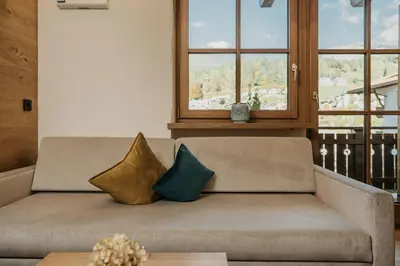 a couch with two pillows on it in a living room at Miraval Perathoner Andreas in Ortisei