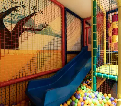 a play room with a slide and balls at Hotel B&B Feldmessner in Brunico