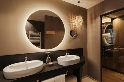 a bathroom with two sinks and a mirror at Hotel B&B Feldmessner in Brunico
