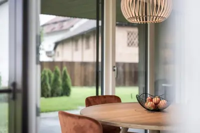 a table with chairs and a bowl of fruit on it at Astor Apartments in Valdaora