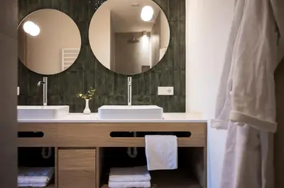 a bathroom with two sinks and a mirror at Astor Apartments in Valdaora