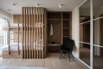 a bedroom with a bunk bed and a chair at Astor Apartments in Valdaora