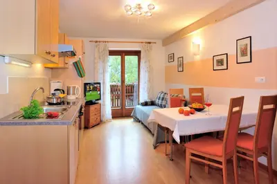 a kitchen and living room with a table and a kitchen and a dining room at Residence Hofer in Bressanone