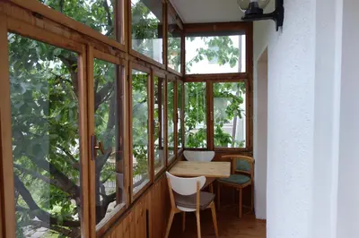 a room with glass windows and a wooden table and chairs at Residence Hofer in Bressanone