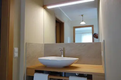 a bathroom with a white sink and a mirror at Residence Hofer in Bressanone
