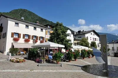 a large pink building with snow in front of it at Hotel Seppi in Mühlbach