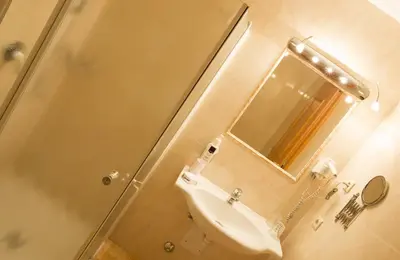 a white bathroom with a shower and a sink at Hotel Seppi in Mühlbach