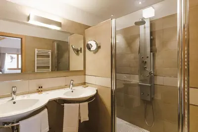 a bathroom with two sinks and a shower at Sayonara Nature & Wellness Hotel in San Martino di Castrozza