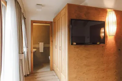 a bathroom with a television on a wall at Sayonara Nature & Wellness Hotel in San Martino di Castrozza