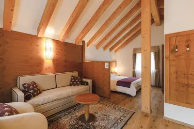 a living room with a couch and a bed at Sayonara Nature & Wellness Hotel in San Martino di Castrozza