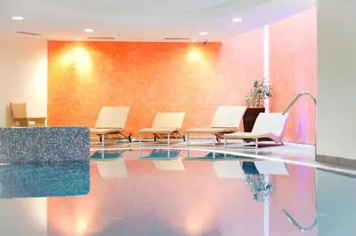 a waiting room with chairs and a pool at Hotel Jolanda in San Martino di Castrozza
