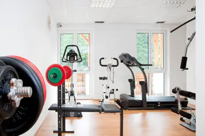 a gym with tread machines and a tire at Hotel Jolanda in San Martino di Castrozza