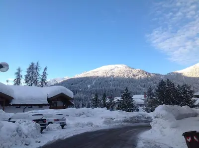a road covered in snow next to a mountain at Hotel Jolanda in San Martino di Castrozza