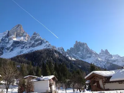 a kite flying in front of a snow covered mountain at Hotel Jolanda in San Martino di Castrozza