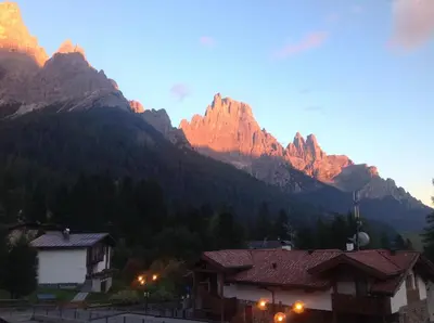 a view of the mountains with a village and buildings at Hotel Jolanda in San Martino di Castrozza