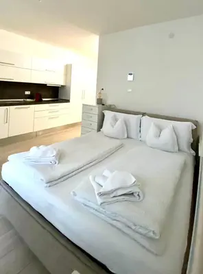 a large white bed with white towels on it at Life Studio & City Bike in Bolzano