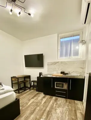 a room with a bed and a sink and a tv at Life Studio & City Bike in Bolzano