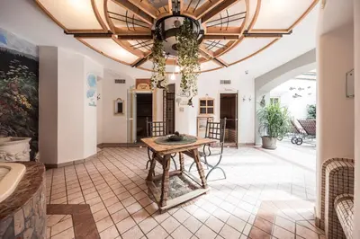 a dining room with a table and a ceiling at Hotel Alpenhof in Ultimo