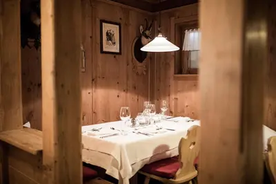 a dining room with a table with wine glasses at Hotel Alpenhof in Ultimo