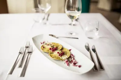 a white plate with some food on a table at Hotel Alpenhof in Ultimo