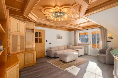 a living room with a ceiling with a chandelier at Wellness Residence Villa Leck in Selva di Val Gardena