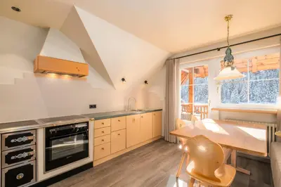 a kitchen with a table and a dining room table at Wellness Residence Villa Leck in Selva di Val Gardena