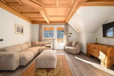 a living room with a couch and a tv at Wellness Residence Villa Leck in Selva di Val Gardena