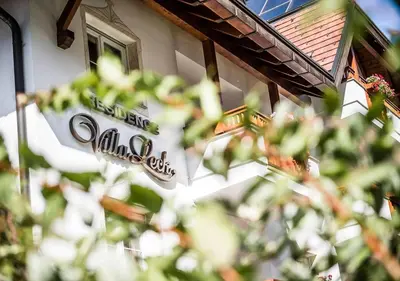 a sign for a restaurant on the side of a building at Wellness Residence Villa Leck in Selva di Val Gardena