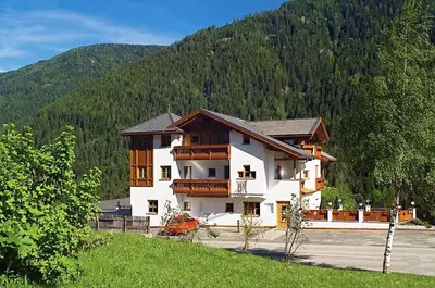 a large house in the middle of a mountain at Hotel Seerast in Ultimo