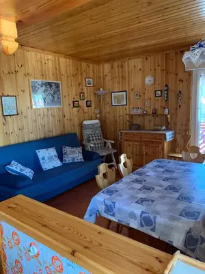 a living room with a blue couch and a bed at Casa Lulu' in Predazzo