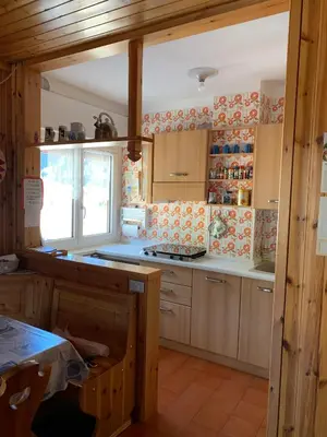 a kitchen with wooden cabinets and a stove top oven at Casa Lulu' in Predazzo