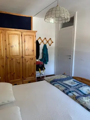 a bedroom with a bed and a chandelier at Casa Lulu' in Predazzo