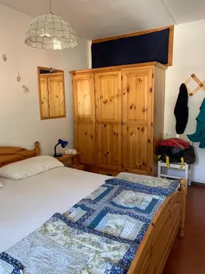a bedroom with a bed and wooden cabinets at Casa Lulu' in Predazzo