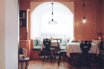 a dining room with a table and chairs and a window at Hotel Gasthaus Post in Campo di Trens