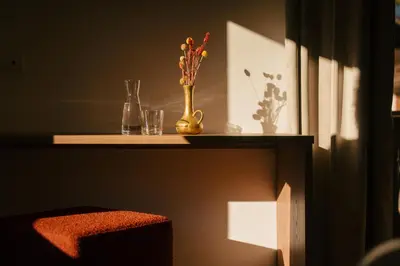 a shelf with a vase of flowers and glasses on it at Hotel Gasthaus Post in Campo di Trens