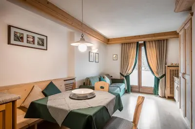 a room with two chairs and two tables with logs at Residence Ciasa Planat in San Cassiano