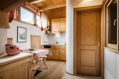 a kitchen with wooden cabinets and a sink at Residence Ciasa Planat in San Cassiano