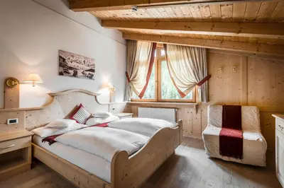 a bedroom with a large bed and a window at Residence Ciasa Planat in San Cassiano