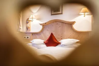 a bedroom with two white beds and a kitchen at Residence Ciasa Planat in San Cassiano