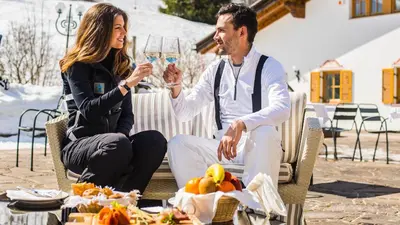 a man and a woman holding a glass of wine at Hotel Hell in Ortisei