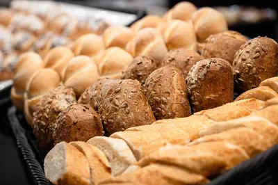 a bunch of different types of bread on a table at Hotel Hell in Ortisei